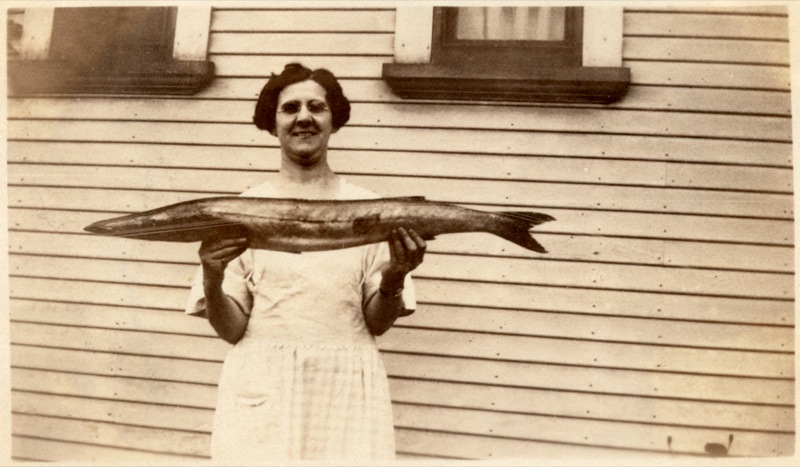 Old photograph of a woman holding a fish